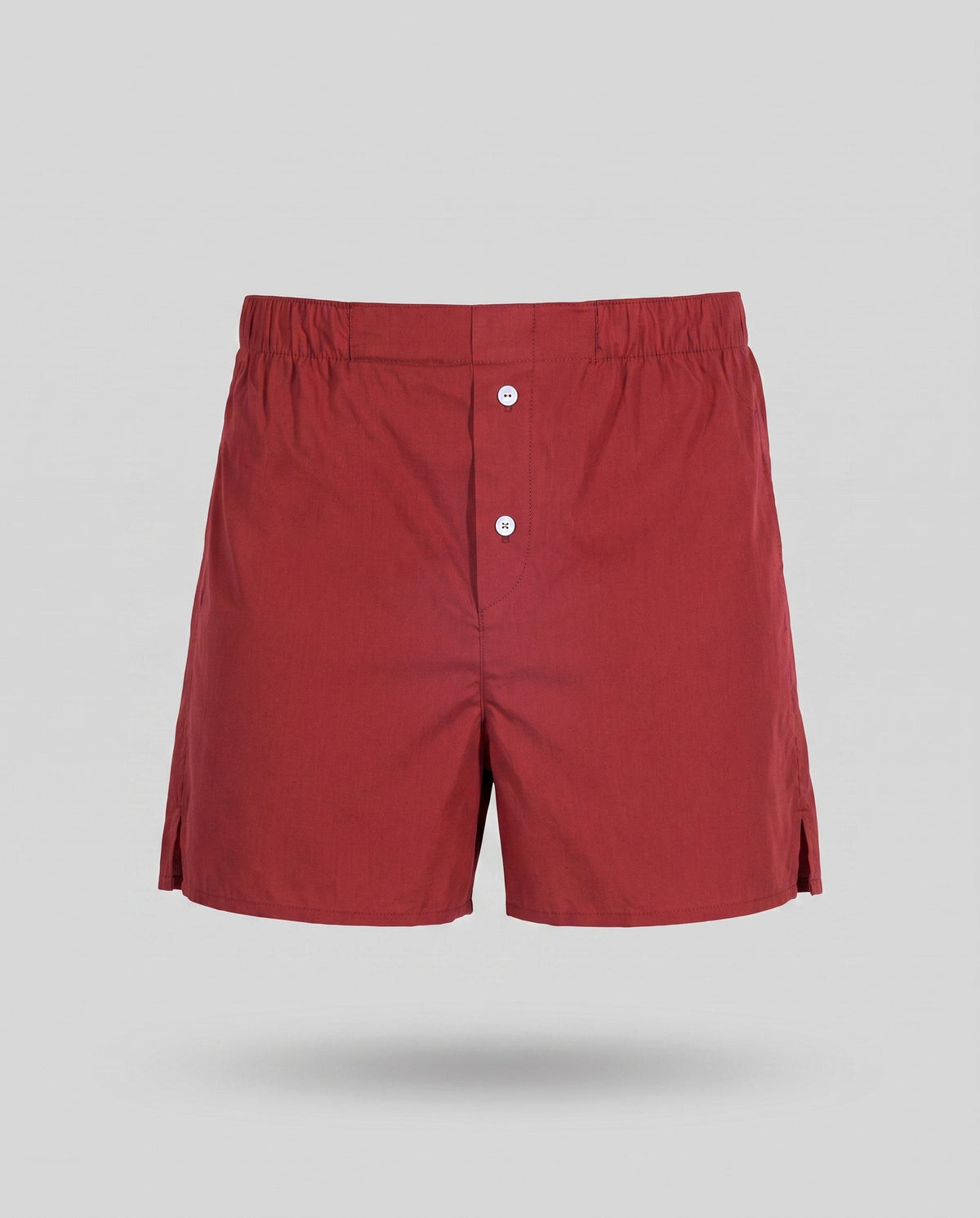 A KAYA brick red cotton boxer on a pale grey backdrop