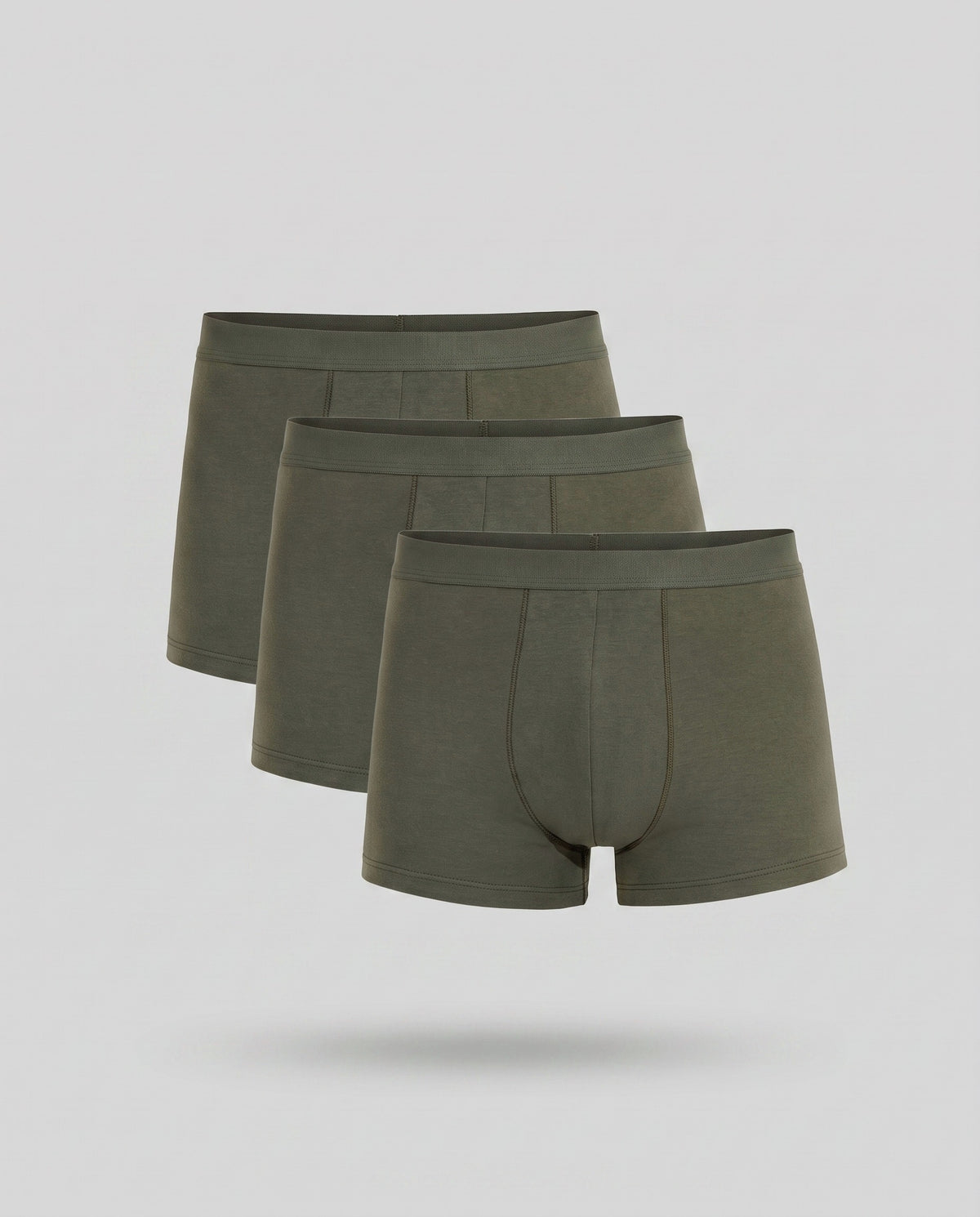 Three KAYA olive cotton trunks stacked on a pale grey backdrop