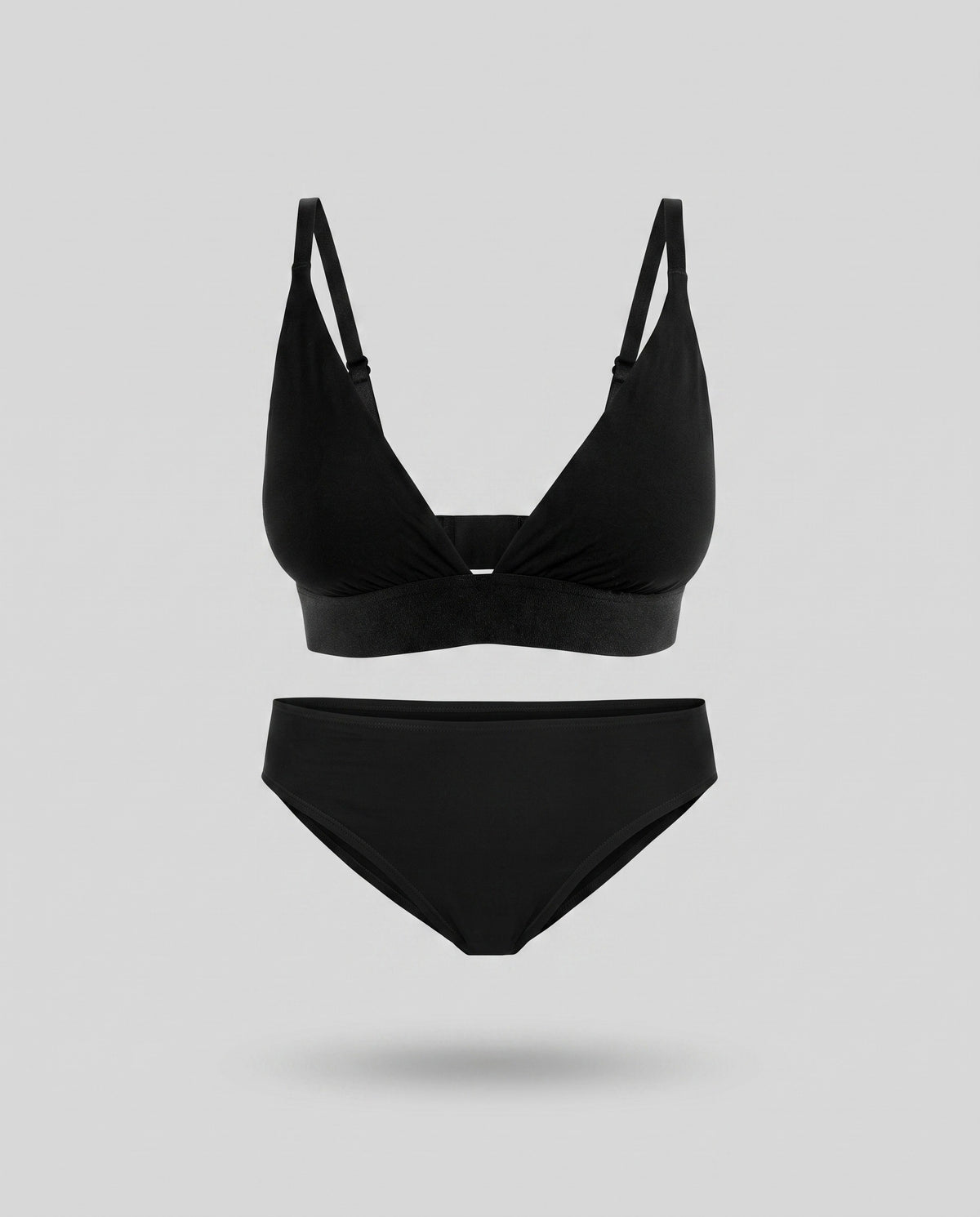 A KAYA black triangle bra and matching bikini brief on a pale grey backdrop