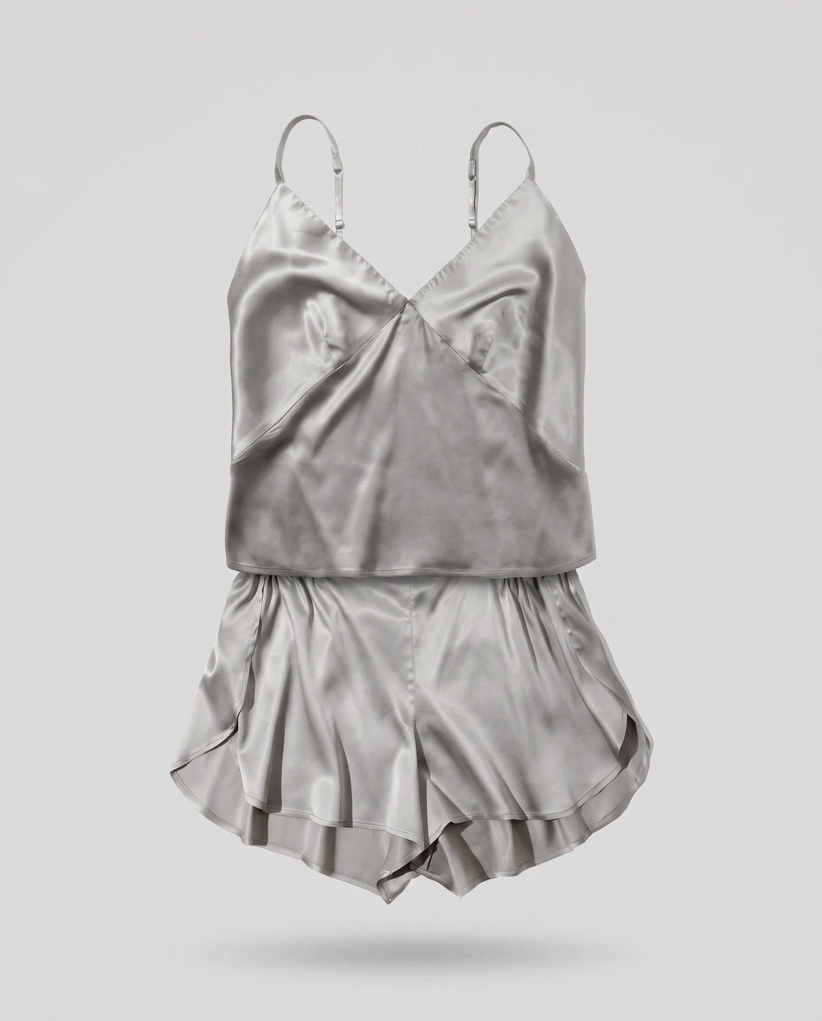 A KAYA silver plant-based silk camisole and matching shorts on a pale grey backdrop