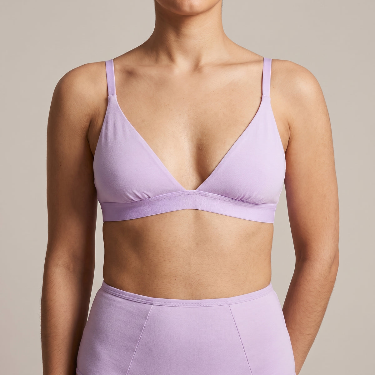 A woman in KAYA's lilac cotton triangle bra and matching high-waist brief, cropped close on the torso